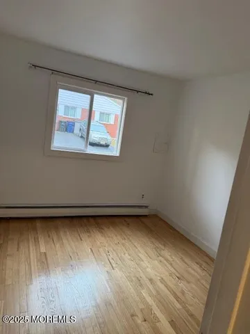 a view of a small space with wooden floor and a window