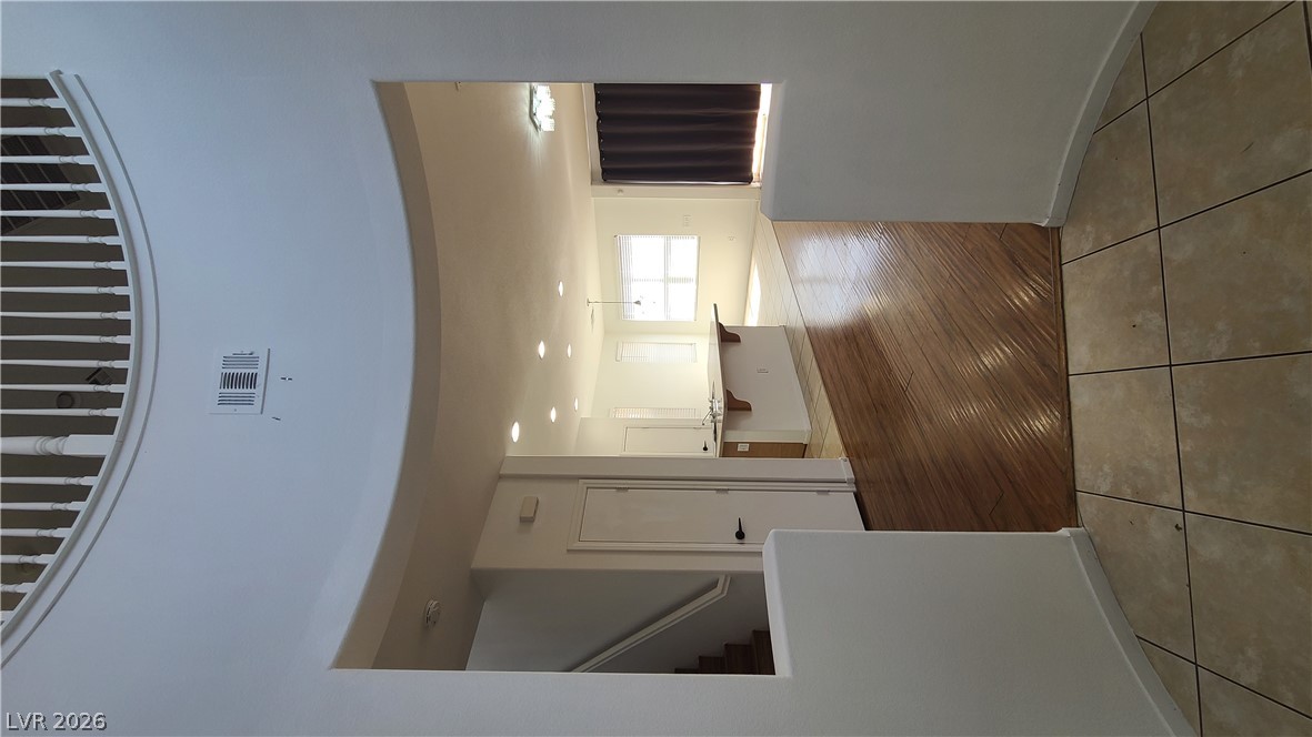 8944 Rutherford Grove Street Las Vegas, NV 89148 - Photo 4 of 35 A spacious entryway with rich wood flooring transitioning to an open-concept living area.