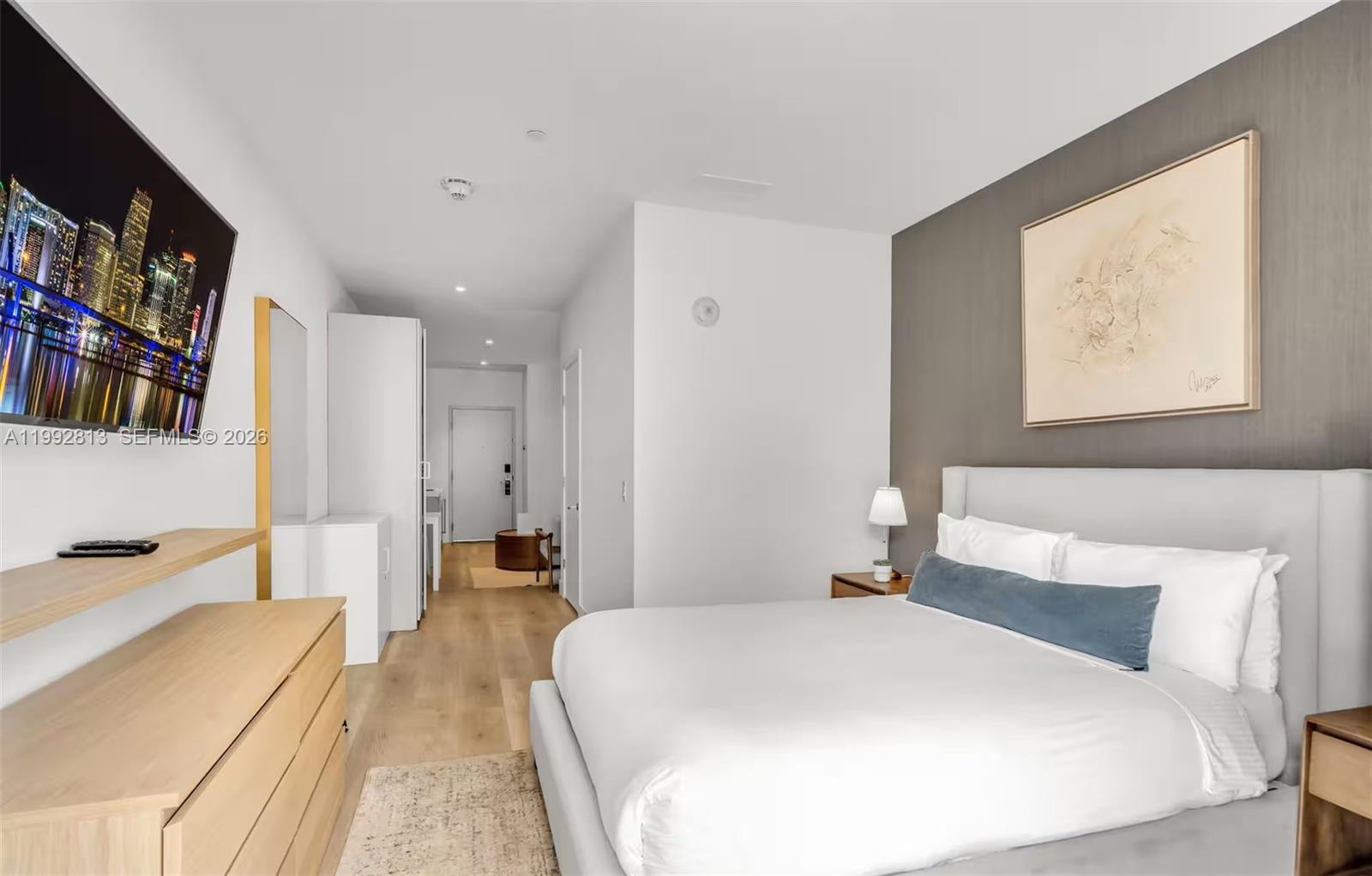 229 Southwest 9th Street, Unit 202 Miami, FL 33130 - Photo 4 of 35 a bedroom with a large bed and a book shelf