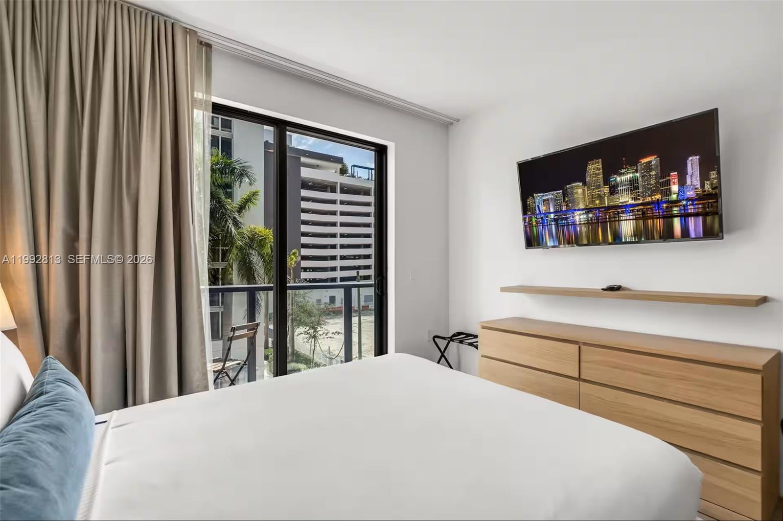 229 Southwest 9th Street, Unit 202 Miami, FL 33130 - Photo 5 of 35 a bedroom with a bed and a large window