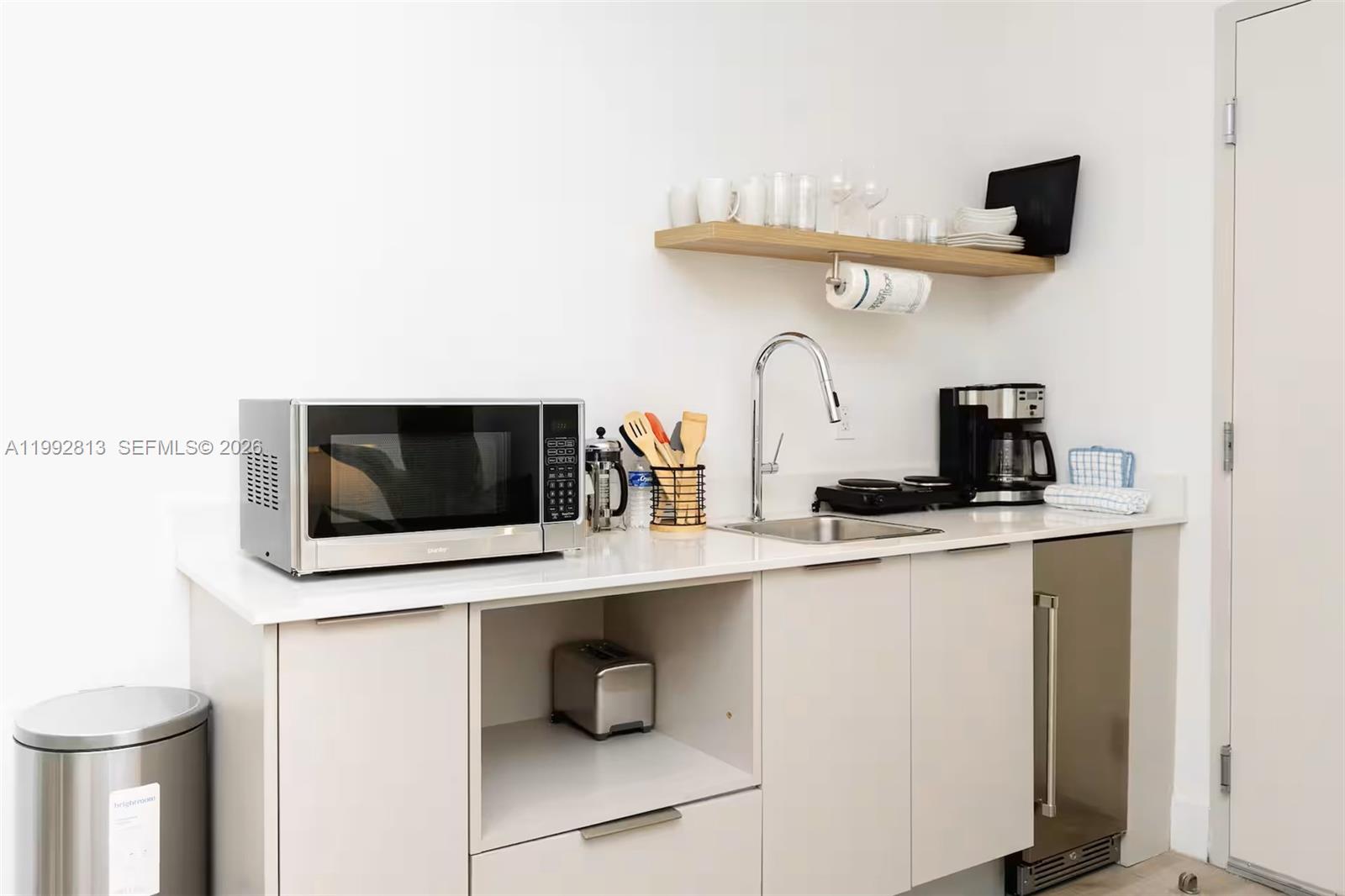 229 Southwest 9th Street, Unit 202 Miami, FL 33130 - Photo 9 of 35 a living room with stainless steel appliances kitchen island a sink a stove and a microwave