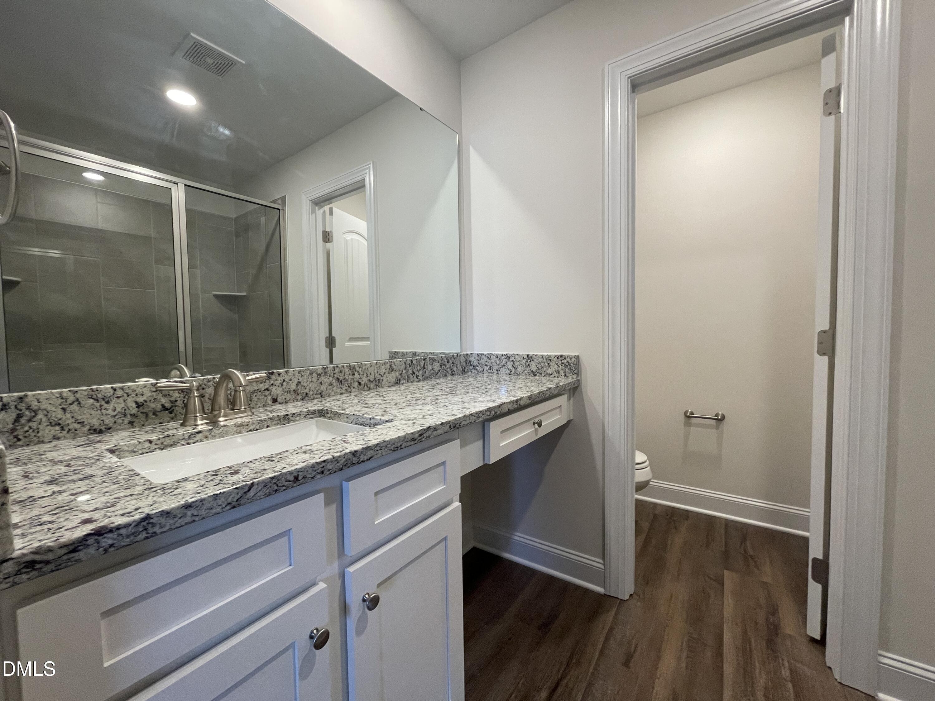 6911 Outfall Point Lane Raleigh, NC 27616 - Photo 25 of 34 a bathroom with a granite countertop sink and a mirror