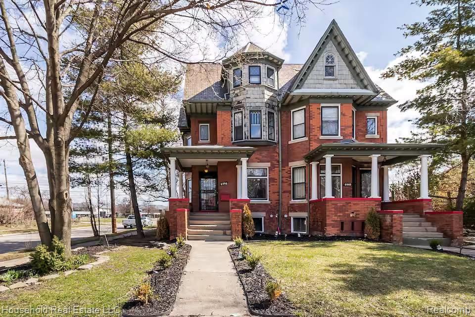 4446 Commonwealth Street Detroit, MI 48208 - Photo 1 of 28 Victorian house with brick siding, a front lawn, and a porch