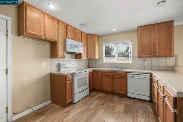 a kitchen with stainless steel appliances granite countertop wooden cabinets a sink and a stove