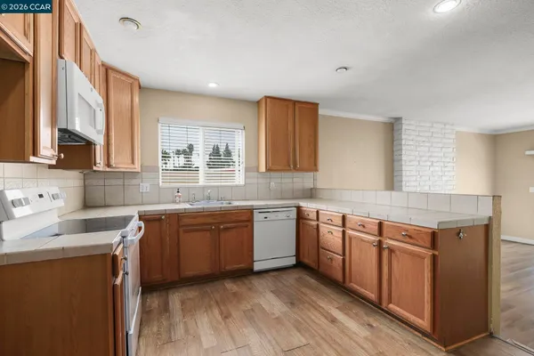 a kitchen with stainless steel appliances granite countertop wooden cabinets sink and stove top oven