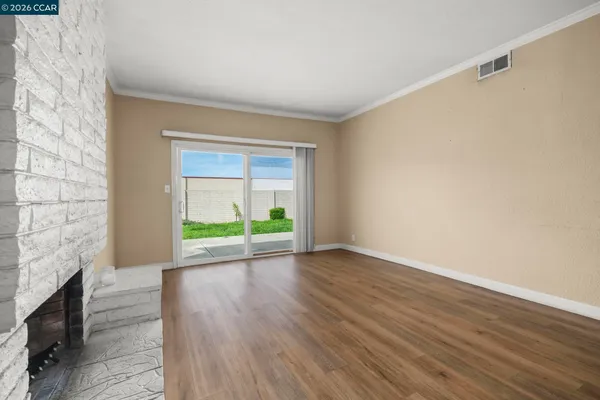 a view of an empty room with a fireplace and a window