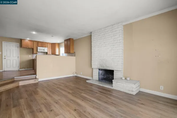 a view of empty room with wooden floor and fireplace
