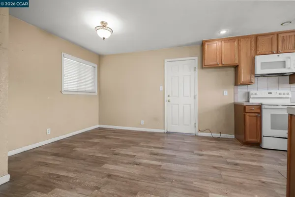 a view of kitchen with a sink wooden floor and cabinets