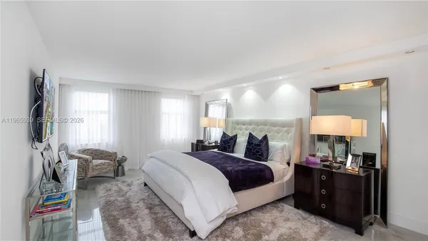 a large bedroom with a bed and a mirror on dresser