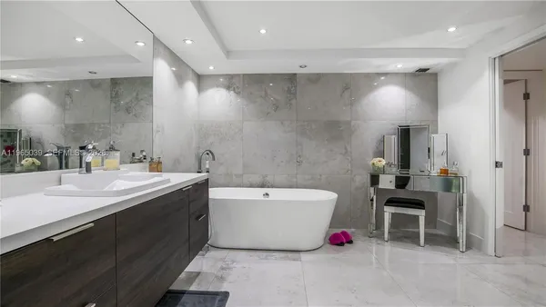 a bathroom with a tub sink a mirror and a shower
