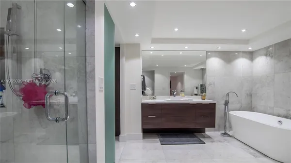 a bathroom with a mirror a bathtub and shower