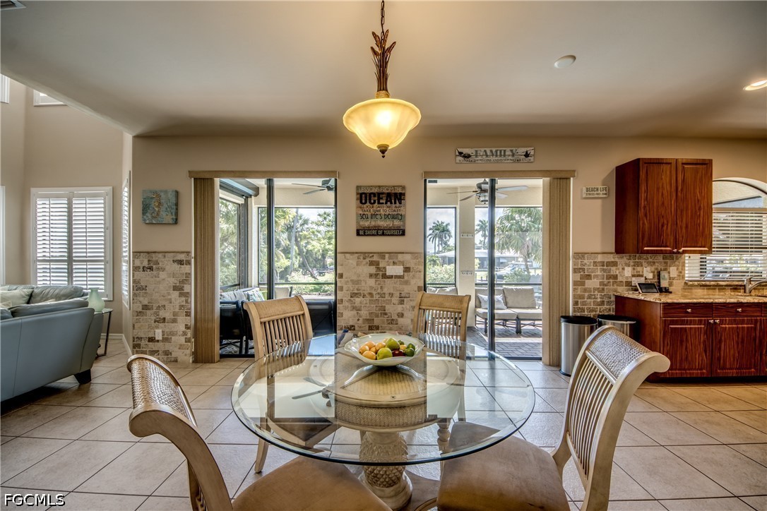5601 Del Rio Court Cape Coral, FL 33904 - Photo 14 of 50 a dining room with furniture a chandelier a large window and stainless steel appliances