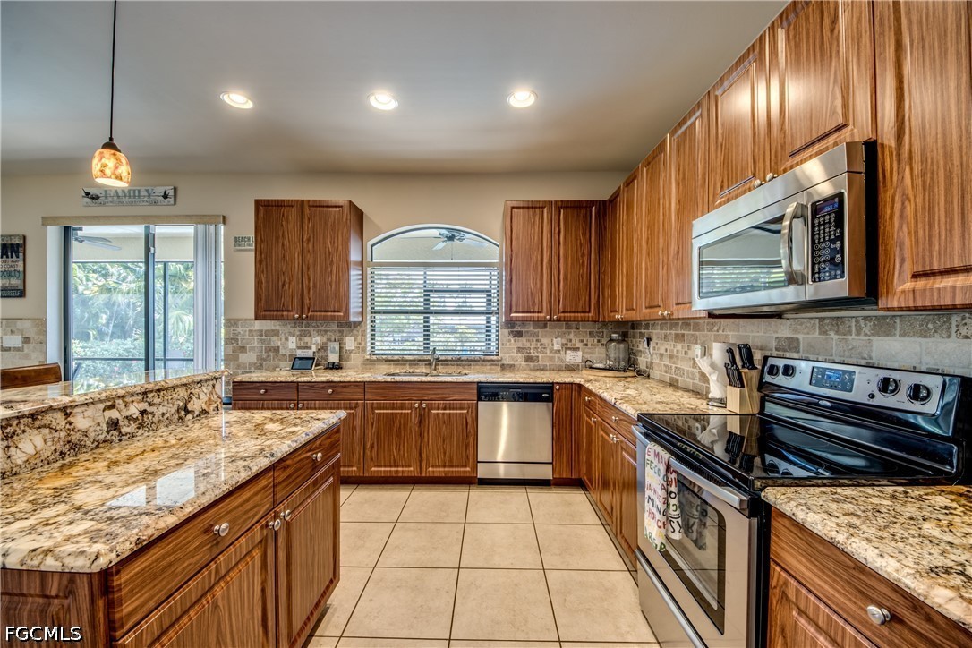 5601 Del Rio Court Cape Coral, FL 33904 - Photo 17 of 50 a kitchen with stainless steel appliances granite countertop a sink stove and cabinets