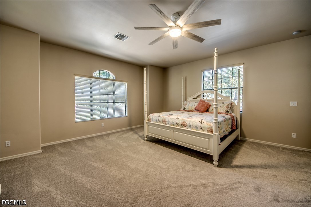 5601 Del Rio Court Cape Coral, FL 33904 - Photo 32 of 50 a bedroom with a large bed and a chandelier