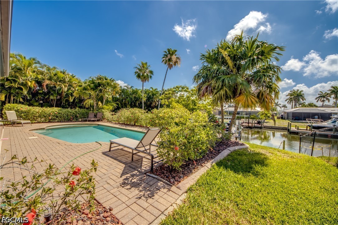 5601 Del Rio Court Cape Coral, FL 33904 - Photo 46 of 50 a view of a swimming pool with an outdoor space and seating area