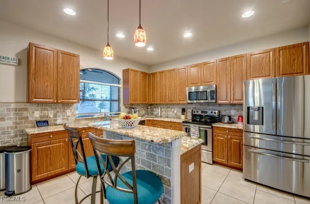 a kitchen with a sink a counter space appliances and cabinets