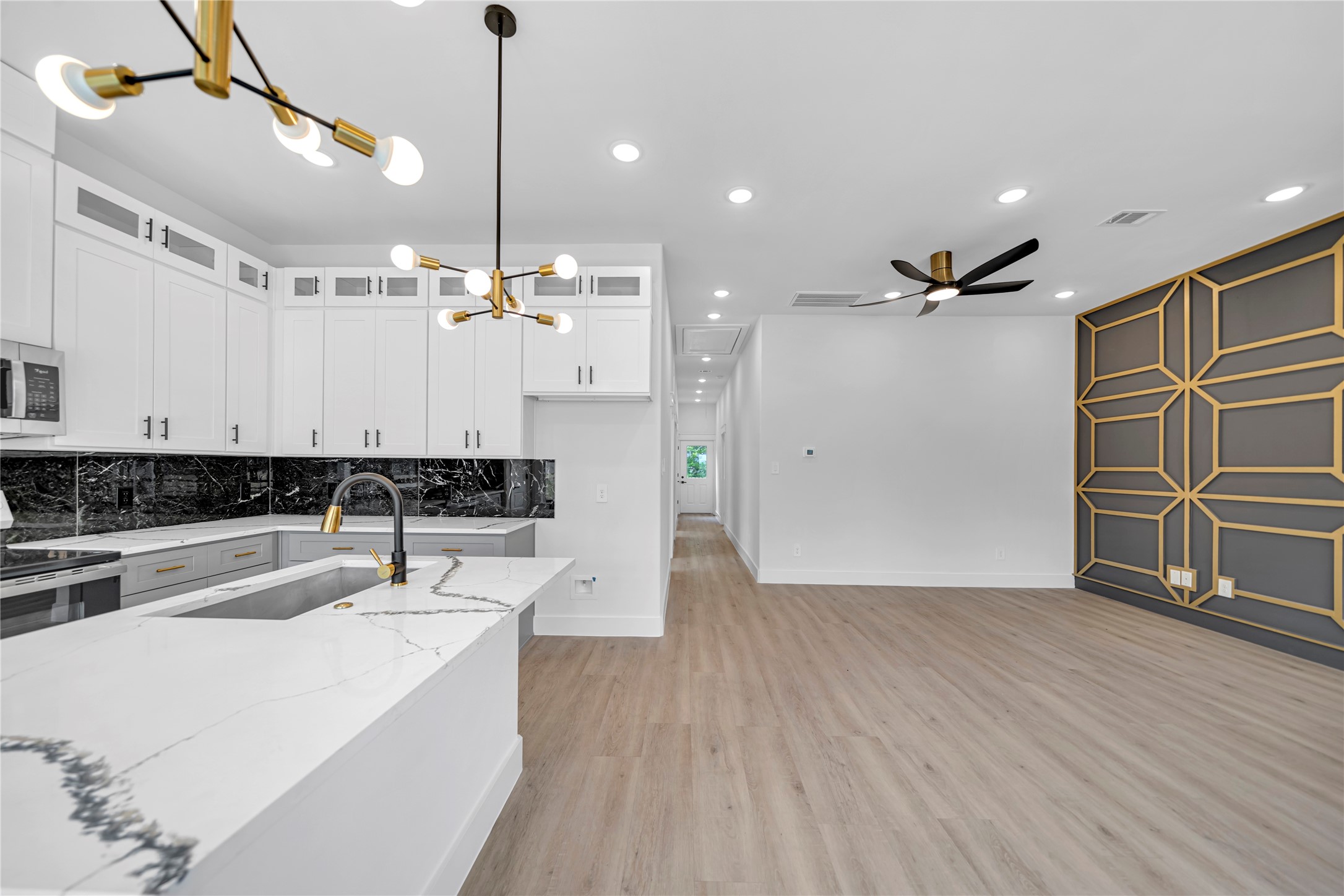 4902 Higgins Street, Unit A Houston, TX 77033 - Photo 6 of 25 a view of a kitchen with kitchen island a sink wooden floor and stainless steel appliances