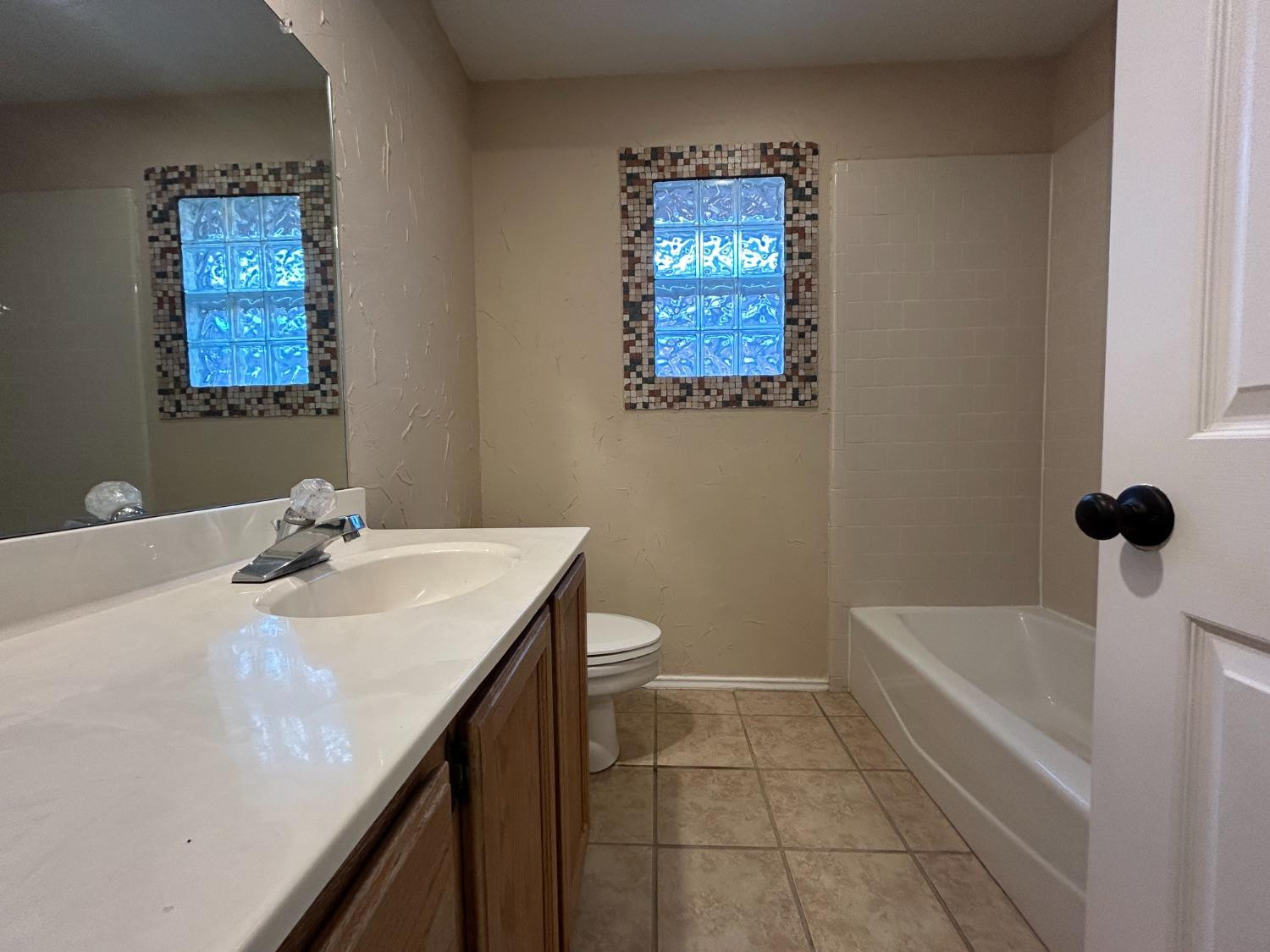 5917 74th Street Lubbock, TX 79424 - Photo 8 of 9 a bathroom with a sink a toilet and shower