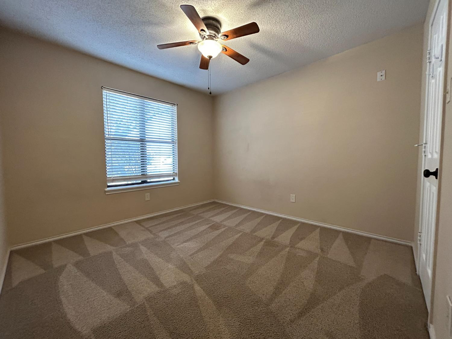 5917 74th Street Lubbock, TX 79424 - Photo 9 of 9 an empty room with windows and fan
