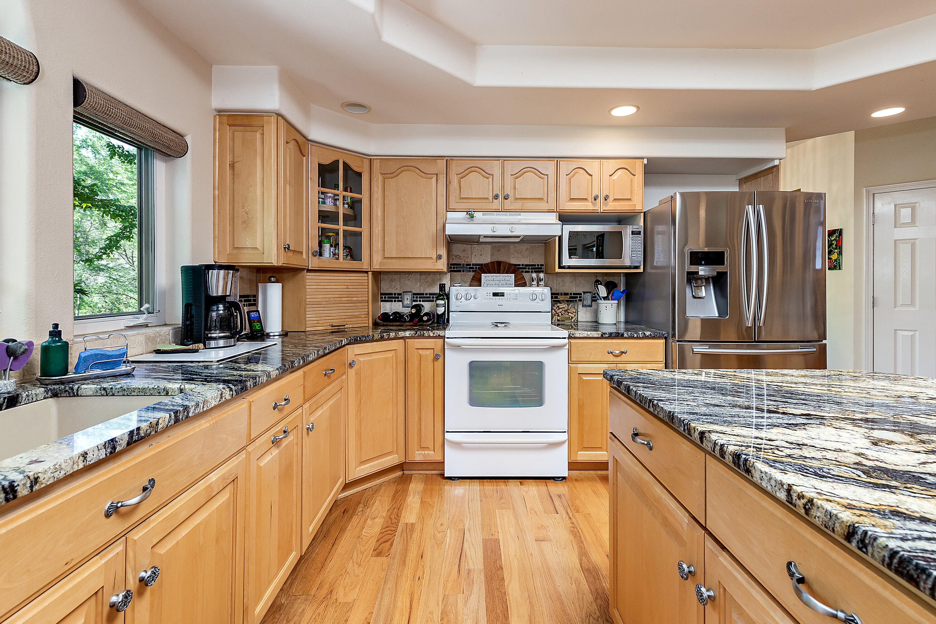 4000 Little Applegate Road Jacksonville, OR 97530 - Photo 18 of 47 a kitchen with stainless steel appliances kitchen island granite countertop a stove top oven a sink dishwasher a refrigerator and a oven with wooden floor