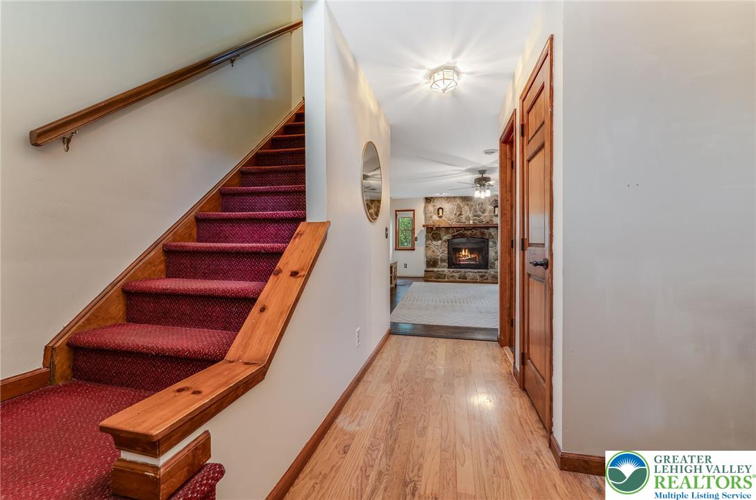 465 Raubsville Road Easton, PA 18042 - Photo 12 of 60 A welcoming entryway with warm Laminate floors leads to a carpeted staircase and a cozy stone fireplace beyond.