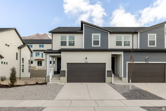 4741 Olive Avenue, Unit 406 Mapleton, UT 84664 - Photo 2 of 20 View of front of house featuring concrete driveway, an attached garage, stucco siding, and roof with shingles