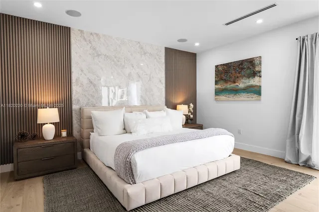 a large white bedroom with a bed and couch