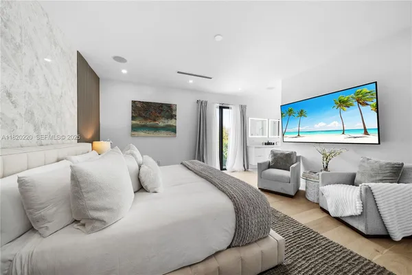 a large white bedroom with a bed and couch