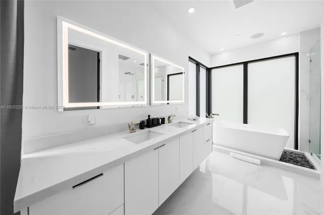 a bathroom with a tub shower sink and mirror