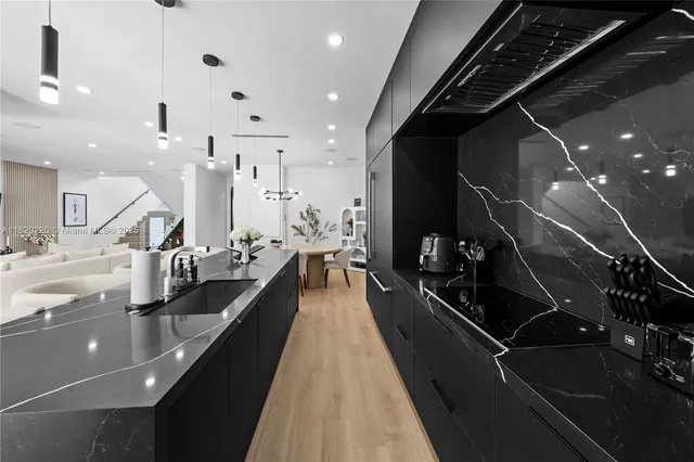 a kitchen with stainless steel appliances kitchen island granite countertop a sink a stove and a refrigerator