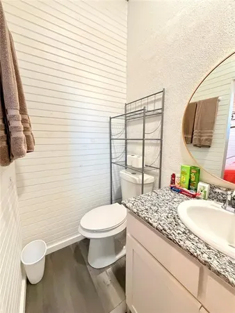 a bathroom with a granite countertop toilet and a sink