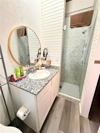 a bathroom with a granite countertop sink and a mirror