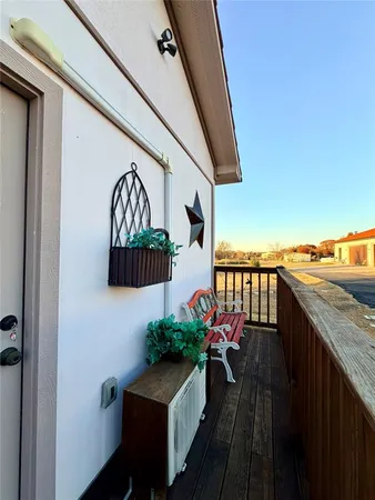 a balcony with wooden floor and potted plant