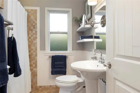 a bathroom with a sink toilet and mirror