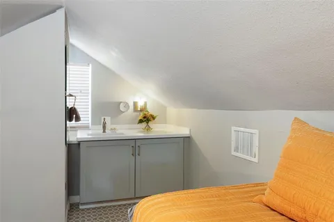 a bedroom with a sink and mirror