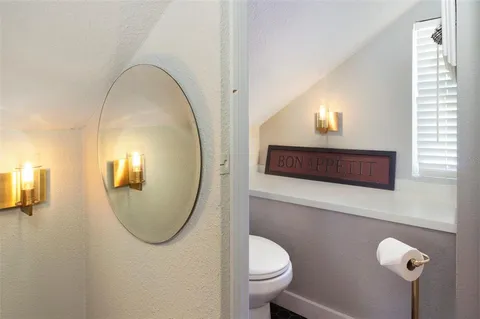 a bathroom with a toilet a sink and mirror