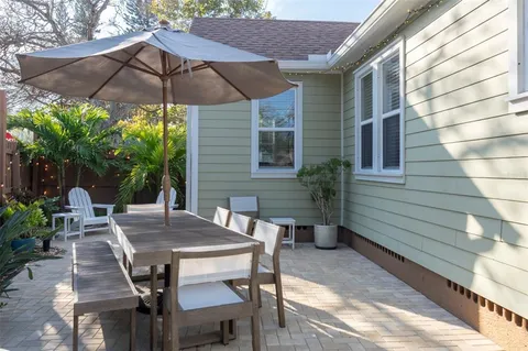a view of a patio with a table and chairs under an umbrella