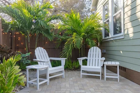 a view of a chairs and table in the patio in front of a house