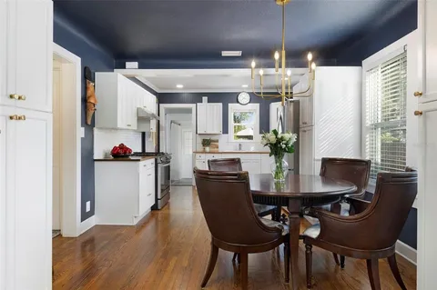 a view of a dining room with furniture a kitchen and chandelier