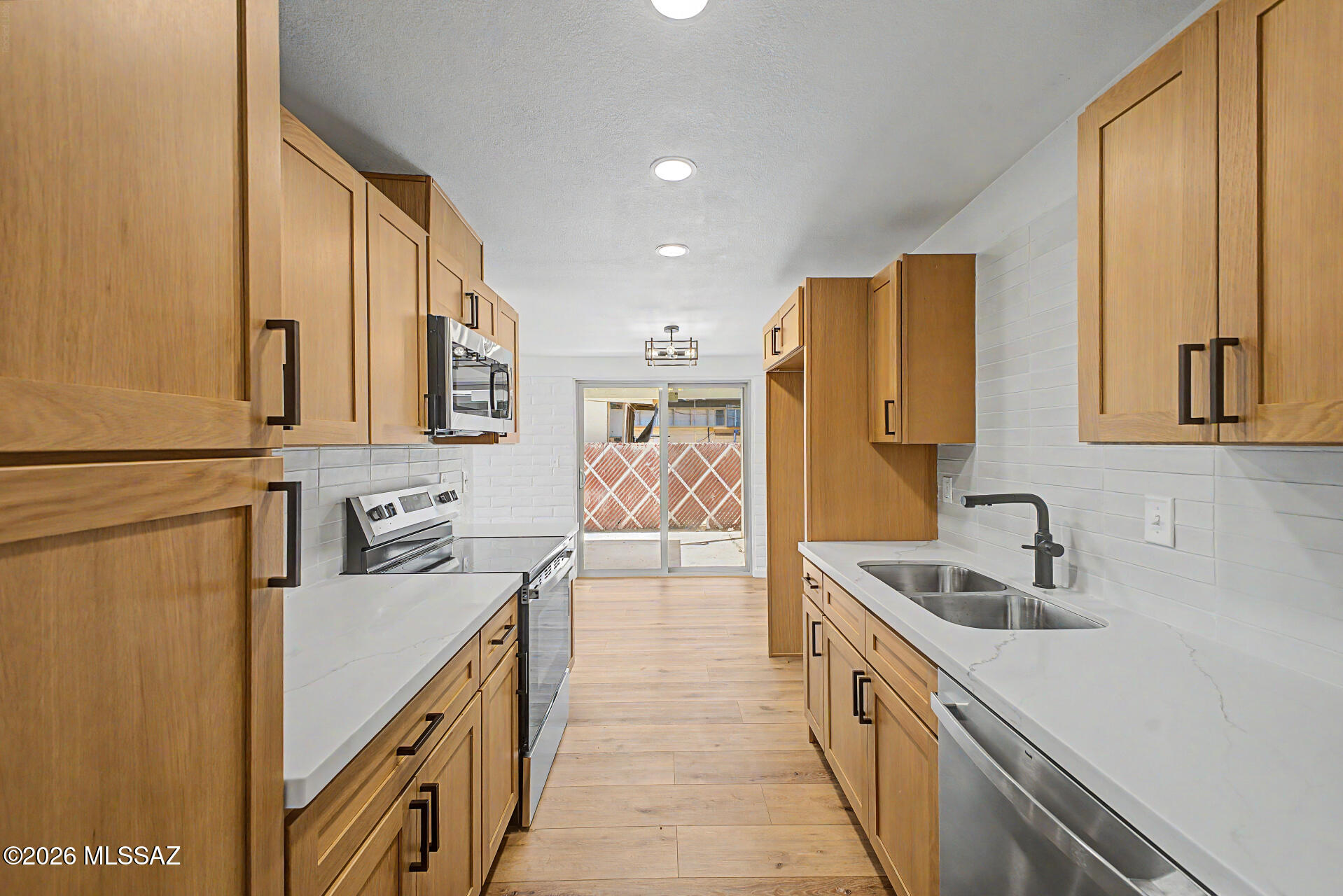 3402 South Kolb Road Tucson, AZ 85730 - Photo 4 of 32 a kitchen with stainless steel appliances a sink stove and cabinets