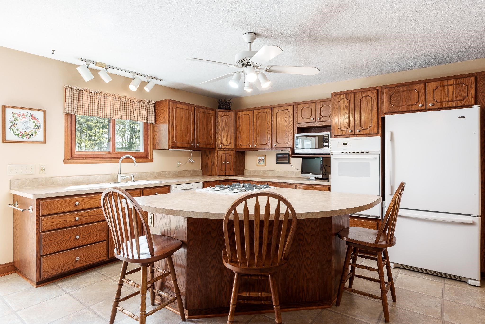 14795 Hansberry Road Rockton, IL 61072 - Photo 17 of 32 a kitchen with a table chairs refrigerator and microwave