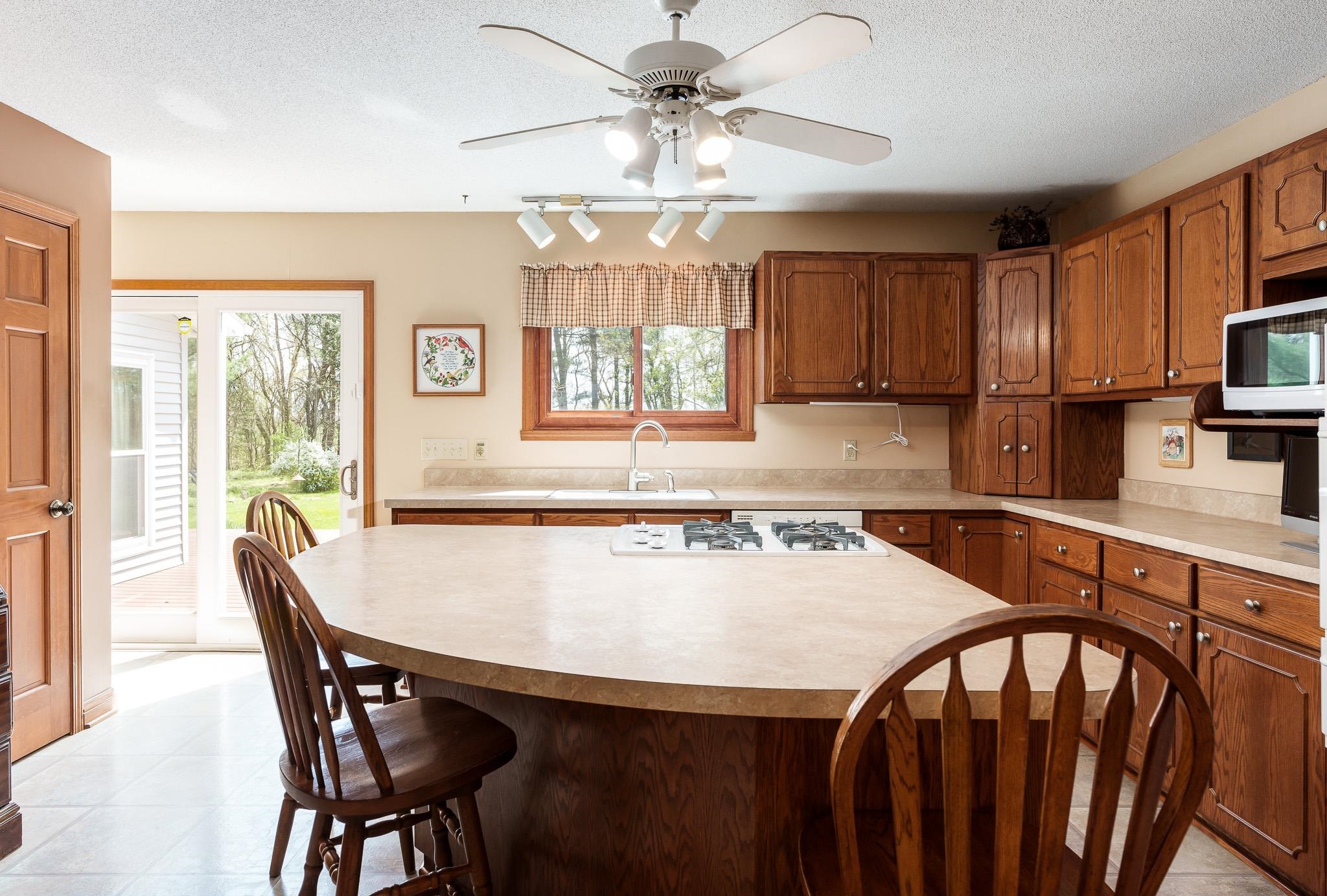 14795 Hansberry Road Rockton, IL 61072 - Photo 18 of 32 a kitchen with stainless steel appliances granite countertop a stove a sink dishwasher and a refrigerator with wooden floor
