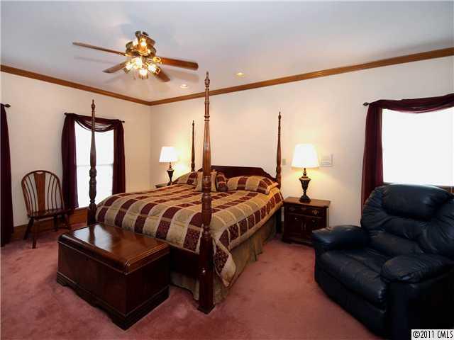 2653 Farmlake Lane Fort Mill, SC 29708 - Photo 8 of 16 a spacious bedroom with a bed couch chandelier and a window