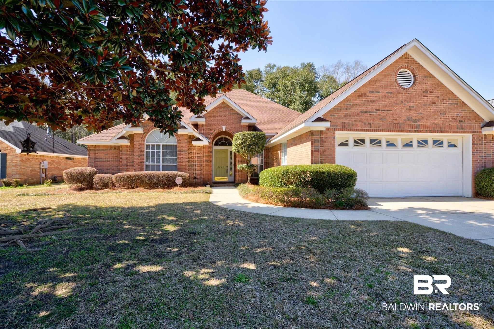 2220 Irongate Court Mobile, AL 36695 - Photo 1 of 20 Traditional-style home featuring a garage, brick siding, concrete driveway, roof with shingles, and a front yard