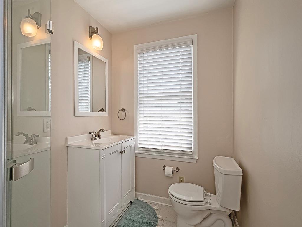 9151 Peebles Road Allison Park, PA 15101 - Photo 19 of 28 a bathroom with a toilet a sink a mirror and a window