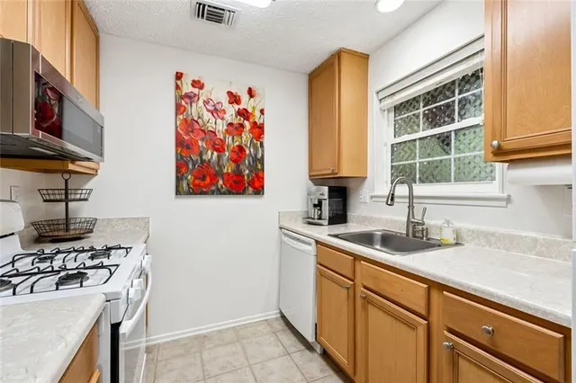 a kitchen with stainless steel appliances a sink a stove and a refrigerator