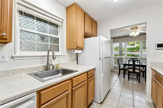 a kitchen with stainless steel appliances granite countertop a sink and a refrigerator