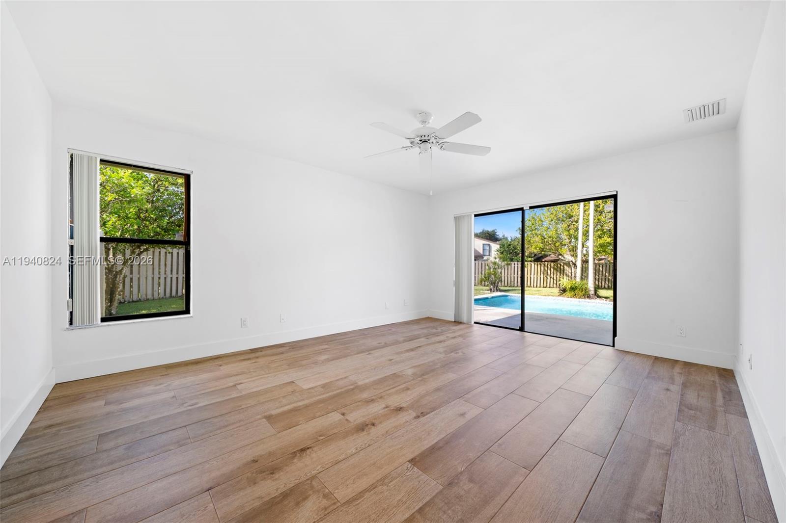 10424 Southwest 114th Court Miami, FL 33176 - Photo 16 of 23 a view of an empty room with a window and wooden floor