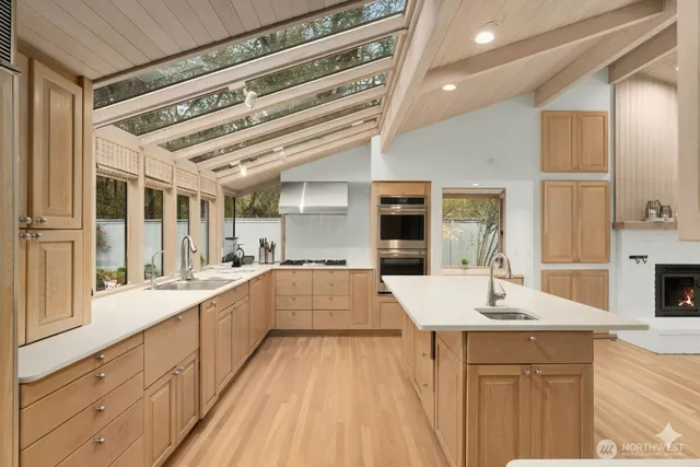 a large white kitchen with kitchen island a stove a sink and a refrigerator