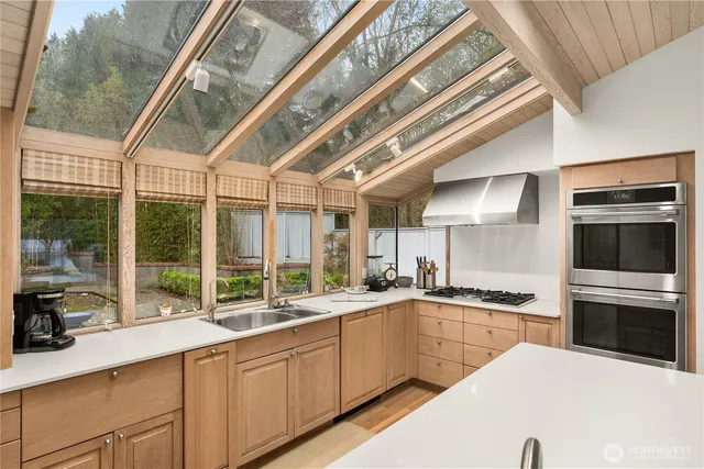 a kitchen with stainless steel appliances granite countertop a sink and cabinets with a large window